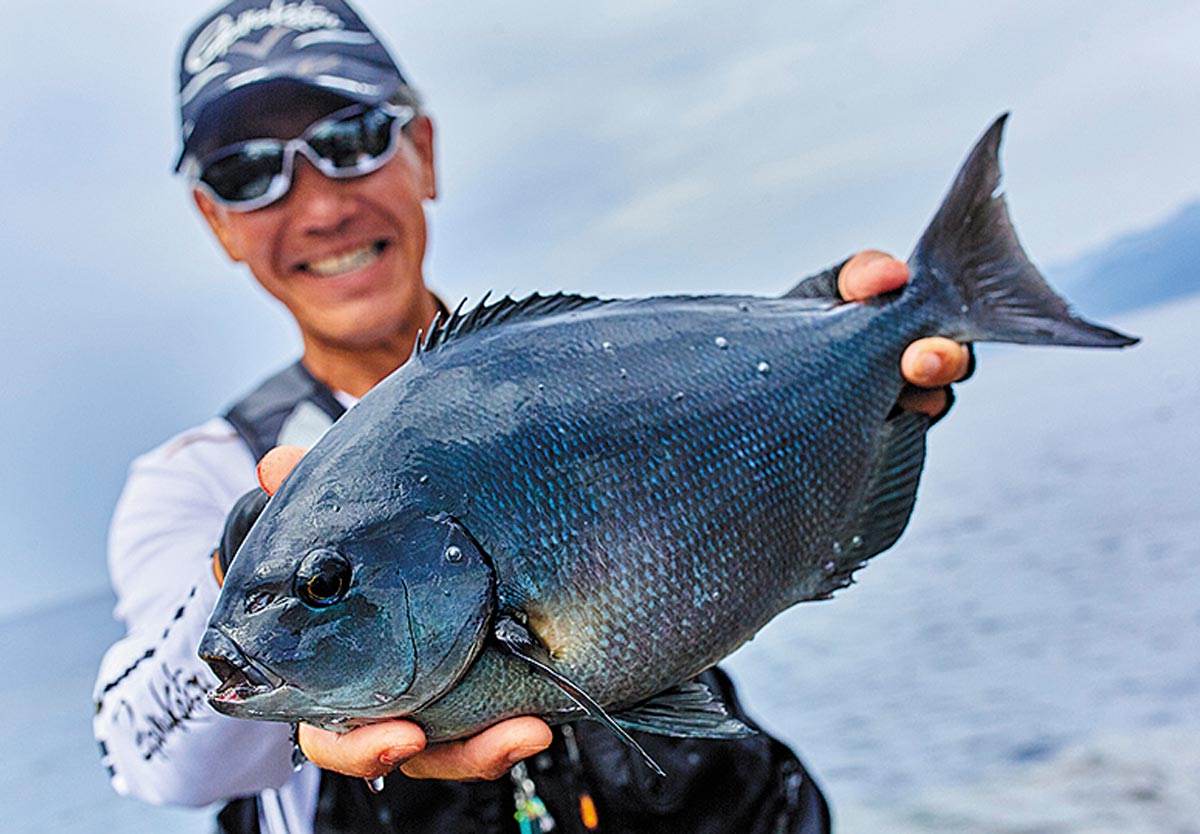 44.5cmのグレを両手に持ち、笑顔の久保野