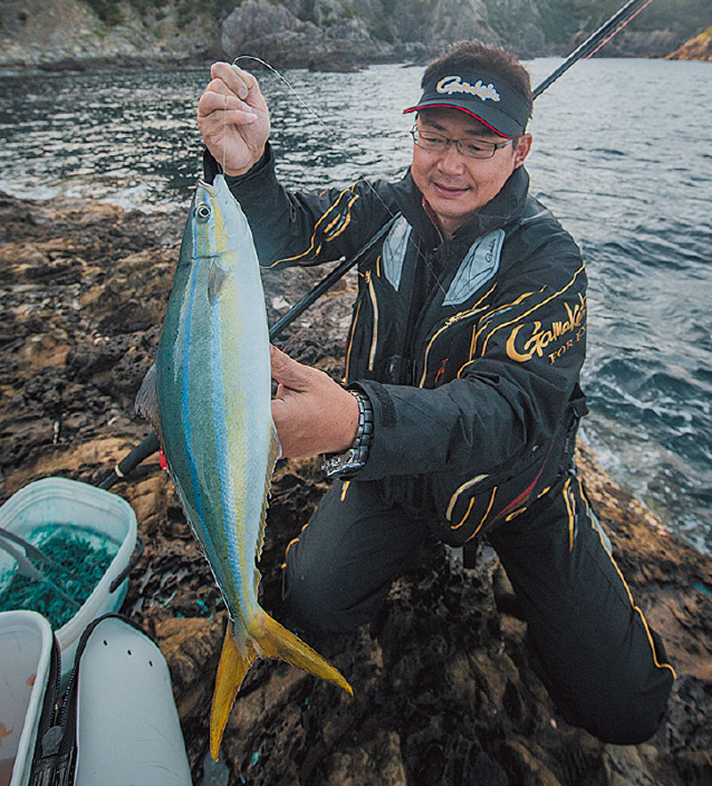 釣り上げたツムブリを持つ鷲尾