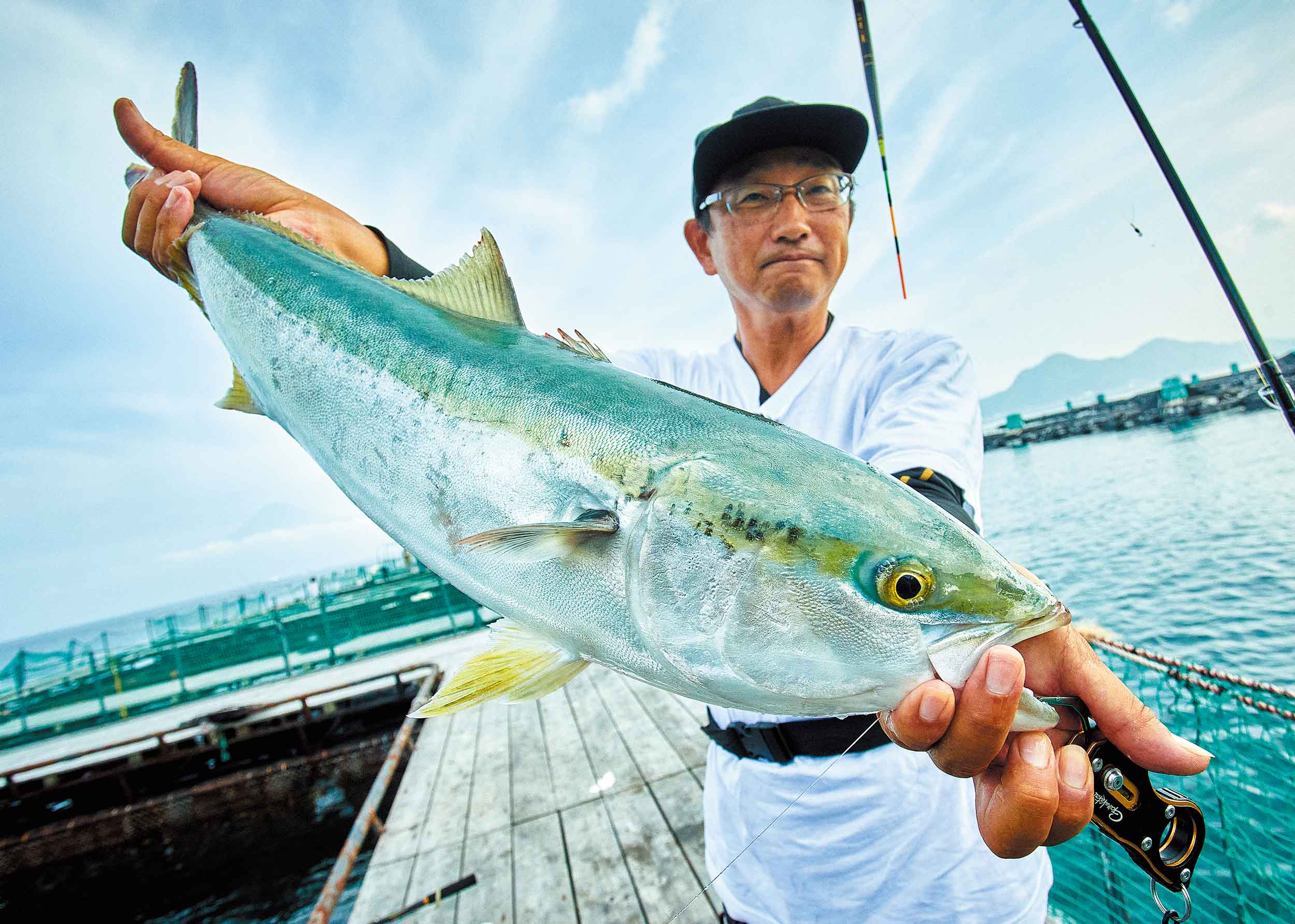 大型のブリを手に笑顔の林